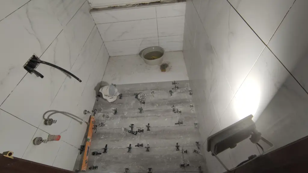 Reforma de baño en Asturias: porcelánico marmolado en paredes y suelo nivelado con crucetas