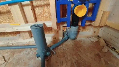 Conexión del desagüe de un inodoro suspendido al manguetón y a la bajante durante la instalación