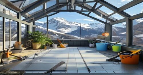 A realistic photo of a modern greenhouse interior in a high mountain setting, showing vinyl flooring installation with radiant heating pipes visible through a partially laid section, with tools like a