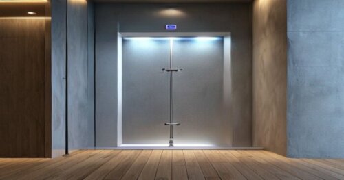 Photorealistic close-up of a modern bathroom shower enclosure with UV-C disinfection system, installed on a floating wood floor and plasterboard walls. The shower door is open, showing the UV-C LED mo