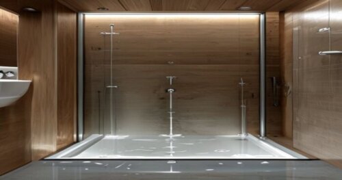 Photorealistic image of a bathroom with a hinged shower screen installed on a liquid porcelain floor, with underfloor heating pipes visible in a cutaway section. The wall is wooden, and there is a sil