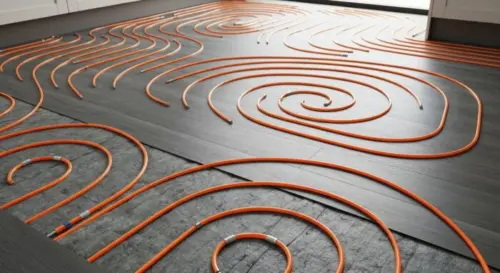 Close-up of a modern kitchen floor installation with radiant heating tubes laid in a serpentine pattern over insulation, with vinyl flooring being installed on top. Natural lighting, realistic materia