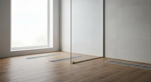 A modern bathroom with a frameless glass shower screen installed on a floating wood floor. The screen is held by hidden wall anchors, no bottom profile. The floor shows a warm wood texture with underf