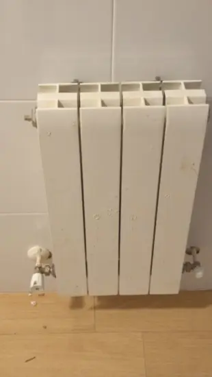 Radiador antiguo con sus llaves antes de sustituirlo por uno nuevo