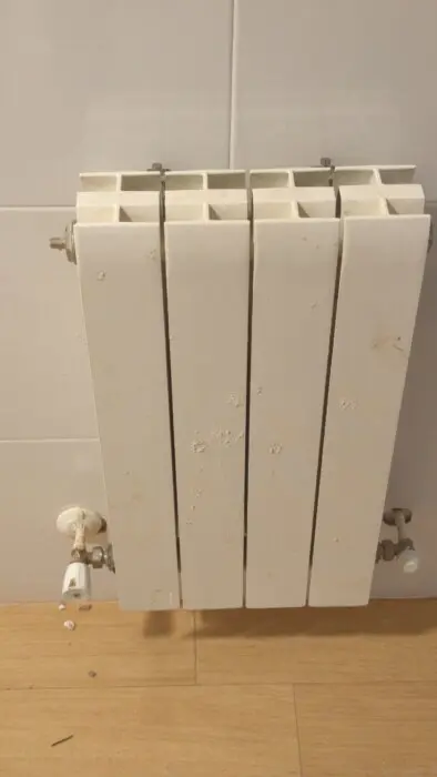 Radiador antiguo con sus llaves antes de sustituirlo, en una vivienda de la cuenca del Caudal