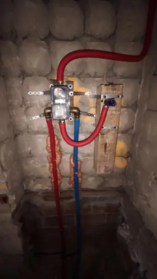 Cuerpo empotrado de grifería fijado a la pared con las tomas de agua fría y caliente antes de cerrar